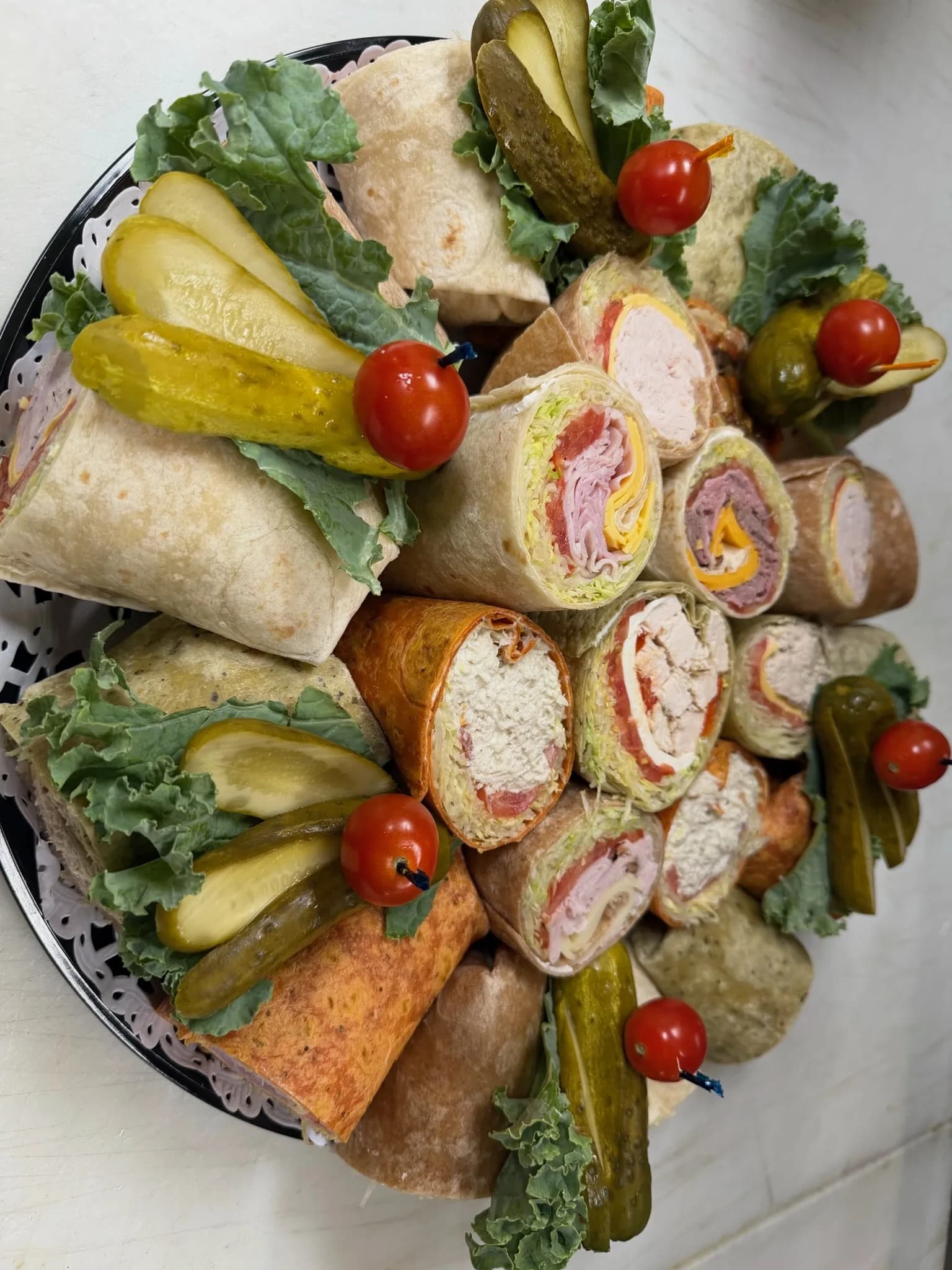 Wrap Platter — full-size wraps quartered and arranged with kale and grape tomatoes for the office spread