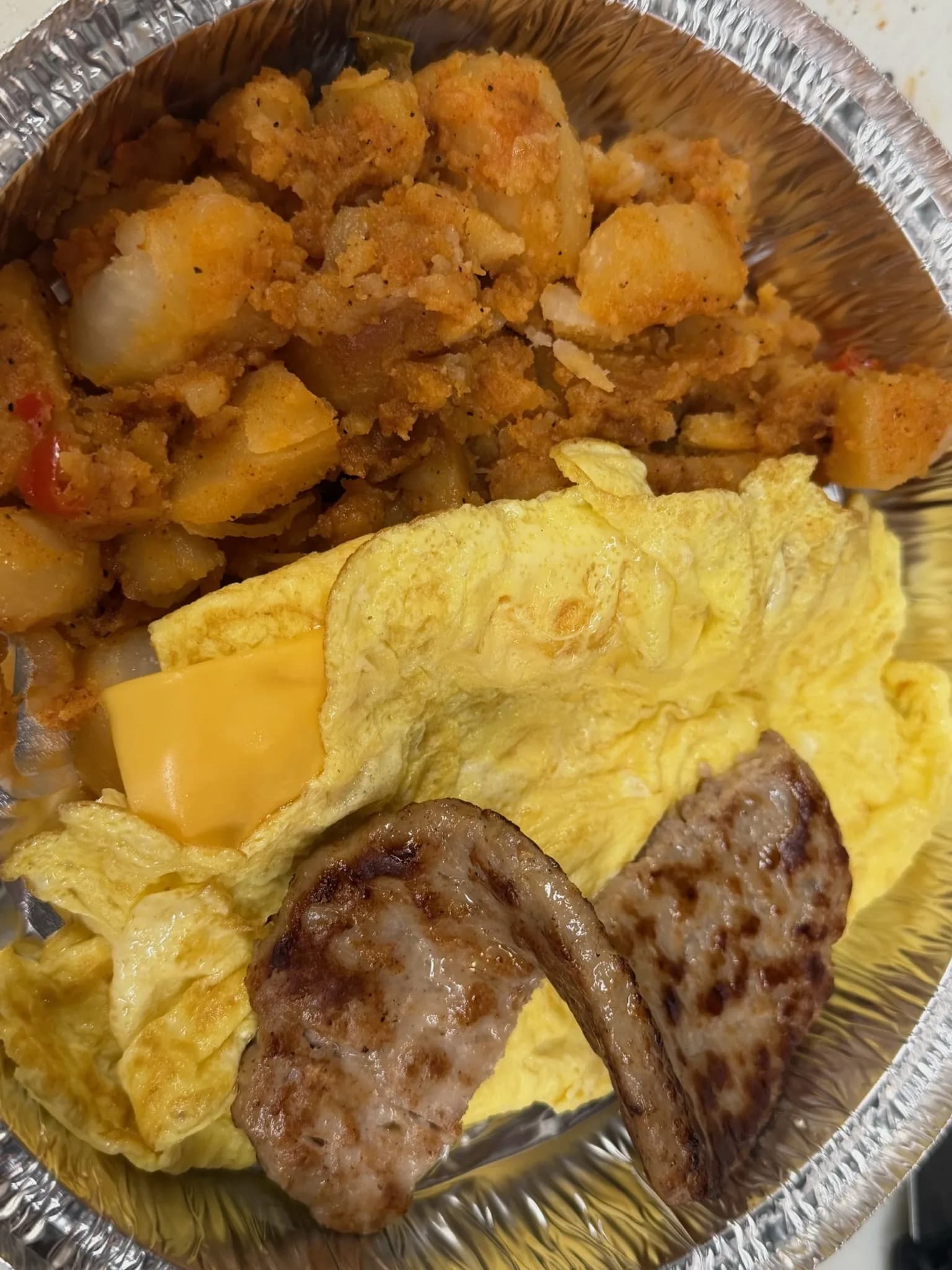 Scrambled eggs and sausage with melted American and a generous mound of home fries